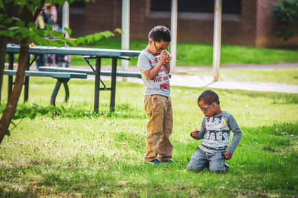 two young male students smell flowers they recently picked outside