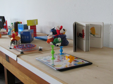 Toys in primary and bright colors sitting on a woden table.