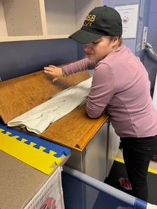 STRIDE student Aeryn Eisner folding a towel at KAC